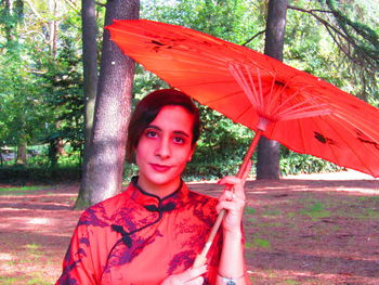 Portrait of woman standing with umbrella in rain