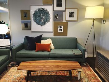 Illuminated floor lamp next to sofa