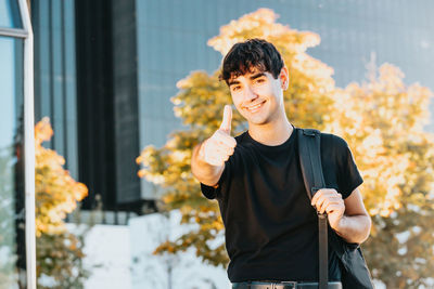 Portrait of young man standing in city