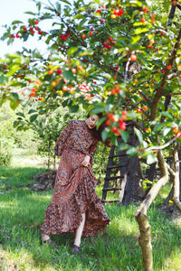 Full length of woman standing by tree