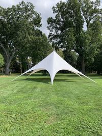 Tent on field against trees in park