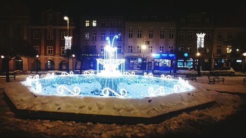 Fountain in city at night