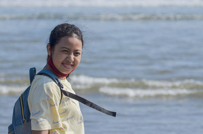 Portrait of smiling woman standing on beach