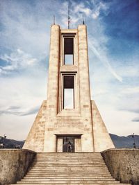 Low angle view of monumento ai caduti against cloudy sky on sunny day