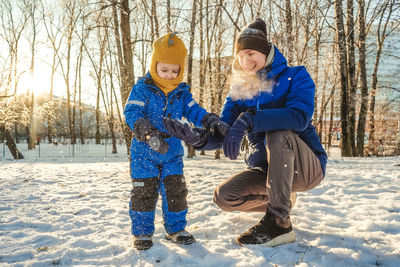 Boy and son on tree during winter