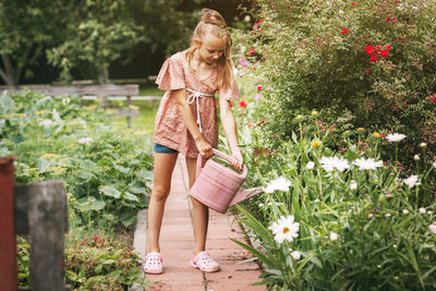 Woman standing by flowering plants