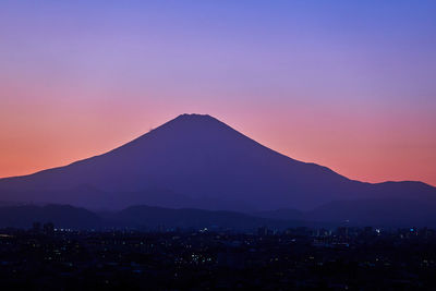 Scenic view of silhouette mountains against romantic sky at sunset