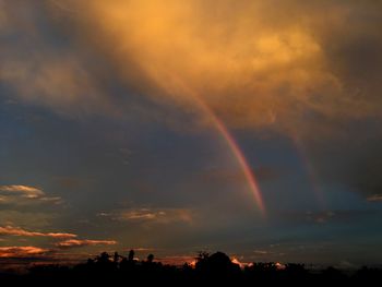 Scenic view of rainbow against sky at sunset