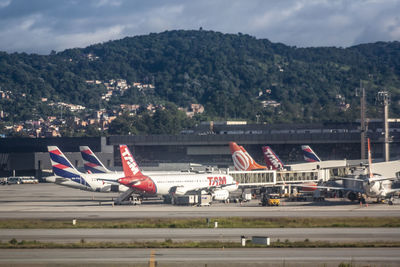 Airplane on airport runway against sky