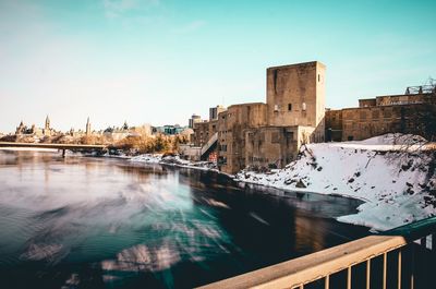 Bridge over river against buildings in city