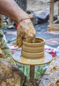 Cropped hands of potter working outdoors