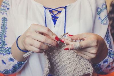 Midsection of woman knitting wool