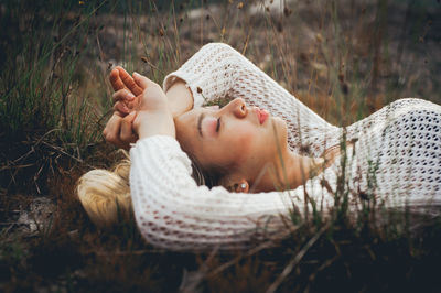 Close-up of young woman resting on grass