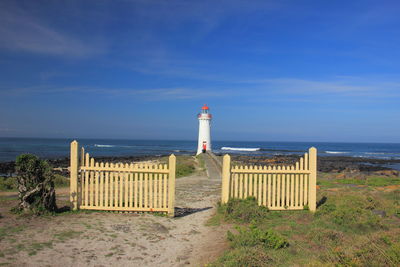 Lifeguard hut on beach against blue sky