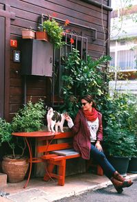 Woman playing with cat on bench