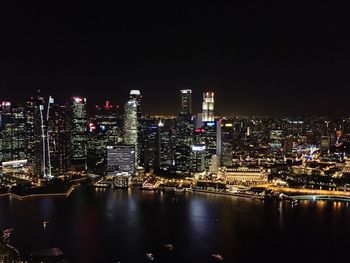 Illuminated cityscape against clear sky at night