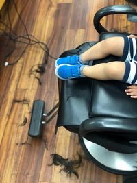 Low section of boy sitting on chair in salon