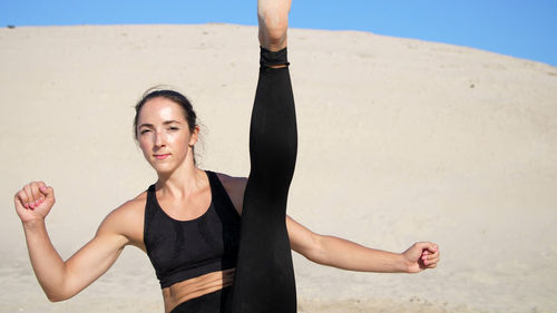 Portrait, athletic girl in a black top, athlete, practice kicks, kicks feet in front of the camera. 