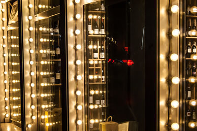 Illuminated lights on glass window at night