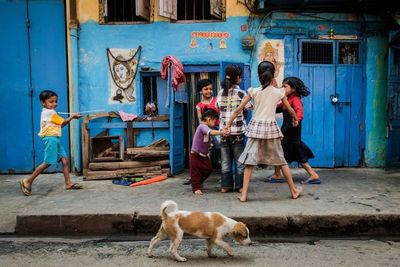 Rear view of people standing with dog