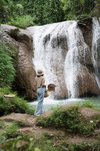 Full length of man standing by waterfall