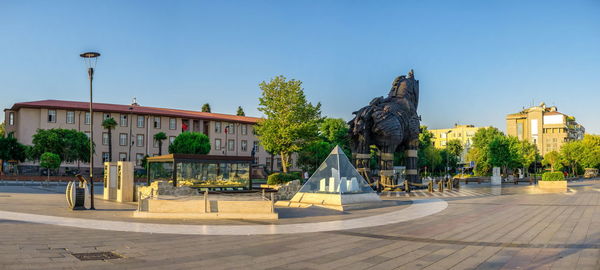 Statue in city against clear sky