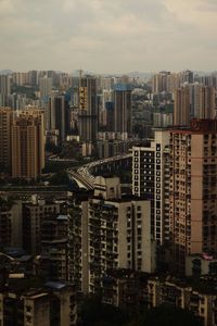 Aerial view of buildings in city against sky