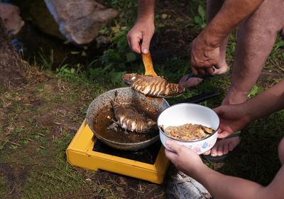 Midsection of man preparing food on barbecue grill