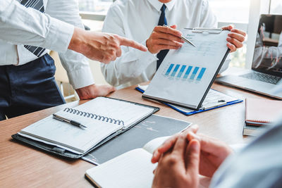 Midsection of business colleagues working on table