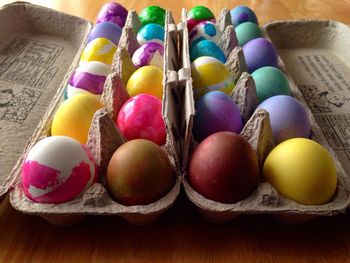 High angle view of multi colored eggs in tray on table