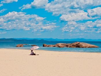 Woman on beach against sky