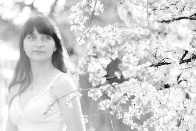 Portrait of young woman with flowers on tree