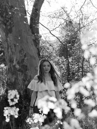 Portrait of teenage girl standing by tree