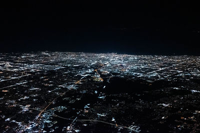 High angle view of illuminated cityscape against sky at night