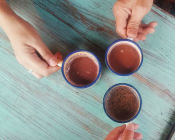 High angle view of woman holding coffee cup on table