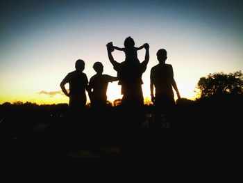 Silhouette men against sky during sunset