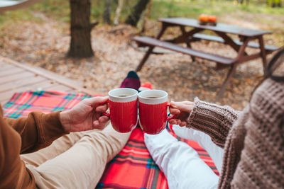 Midsection of woman holding coffee on table