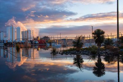 Scenic view of factory against sky during sunset