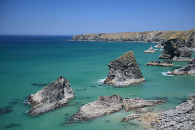 Scenic view of rocks in sea against sky