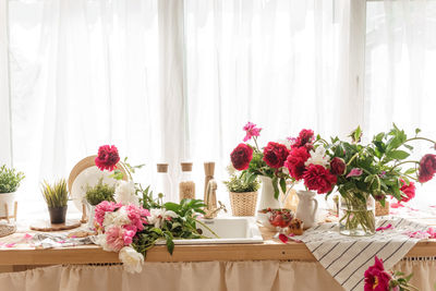 The kitchen countertop is decorated with peonies. the interior is decorated with spring flowers.