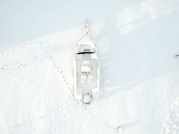 Cross on snow covered land against clear sky