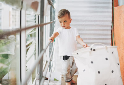 Cute boy looking away standing at home