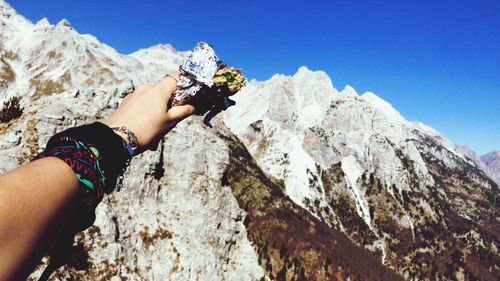 Midsection of man holding rock against sky