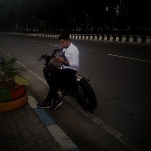 Man riding bicycle on road in city