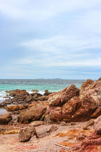 Rock formations on beach against sky