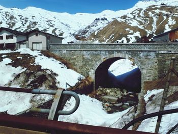 Snow covered buildings against mountain