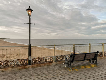 Street light by sea against sky