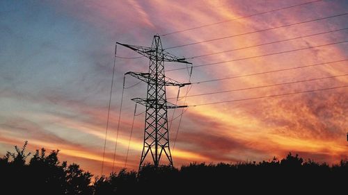 Silhouette of electricity pylon at sunset