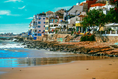 Buildings by sea against sky in city