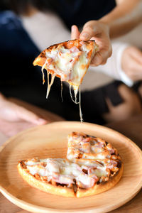 Close-up of hand holding pizza